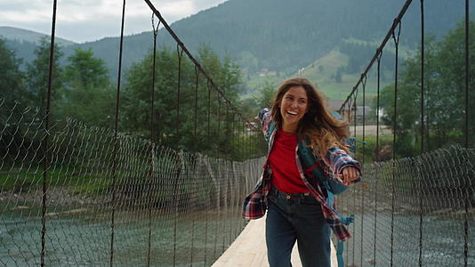 微笑的女孩在山河大桥上远足森林视频的预览图