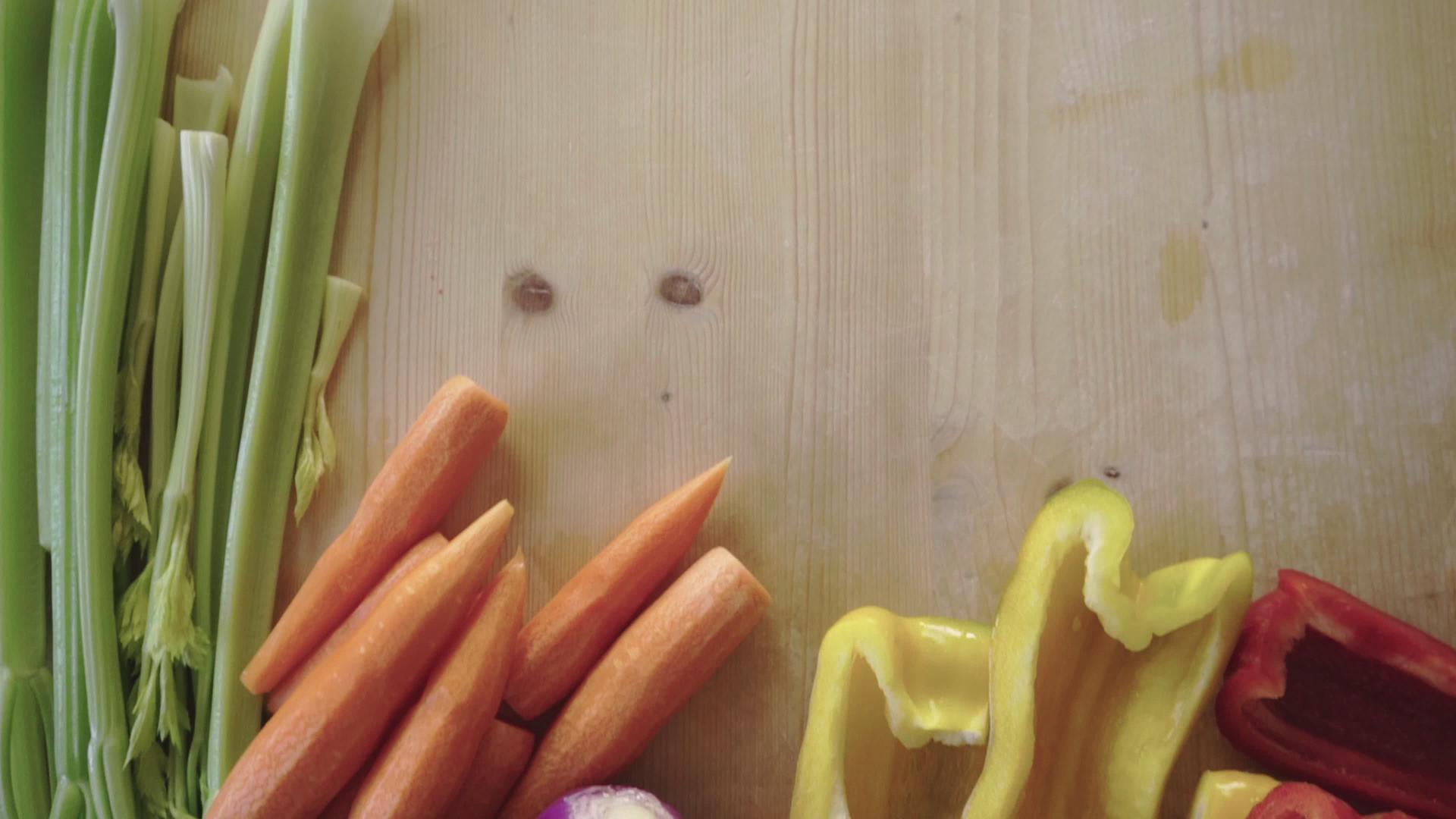 浅木工作台上的胡萝卜、芹菜、辣椒、洋葱视频的预览图