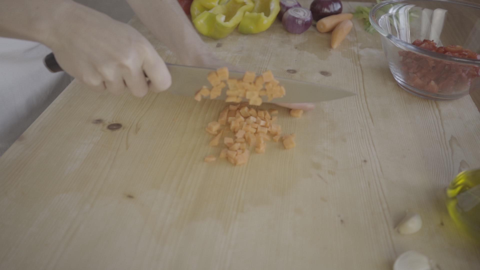 一位年轻的女厨师在家里切胡萝卜视频的预览图