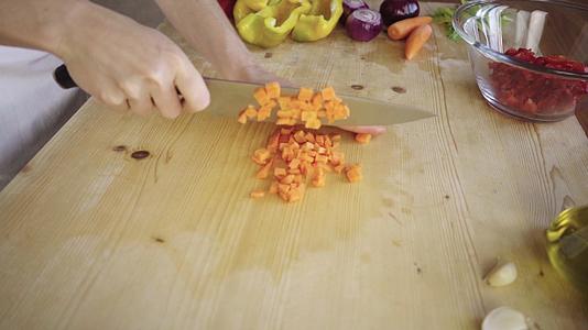 一位年轻的女厨师切胡萝卜视频的预览图