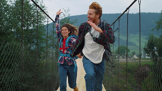 情感情侣旅行者在山桥上奔跑视频的预览图