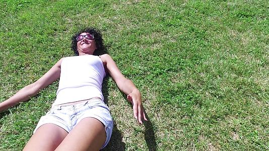 一个男人向一个躺在草地上帮她站起来的漂亮女人伸出助她站起来伸出了四千只手视频的预览图