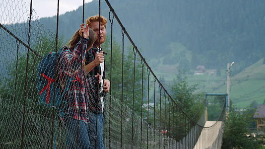 积极的夫妇站在山上的桥上视频的预览图