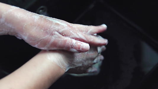为了防止旅行人们用肥皂在热水中洗手以显示他们的手卫生视频的预览图
