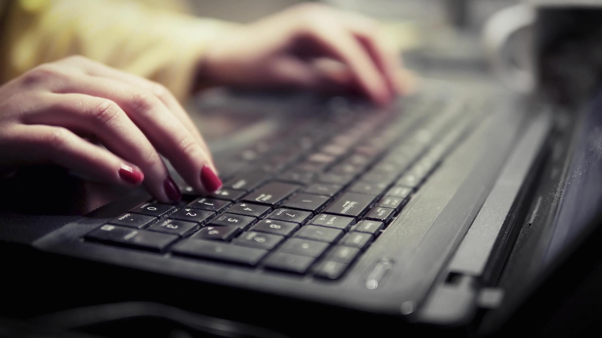 晚上在电脑键盘上打字的女用手视频的预览图