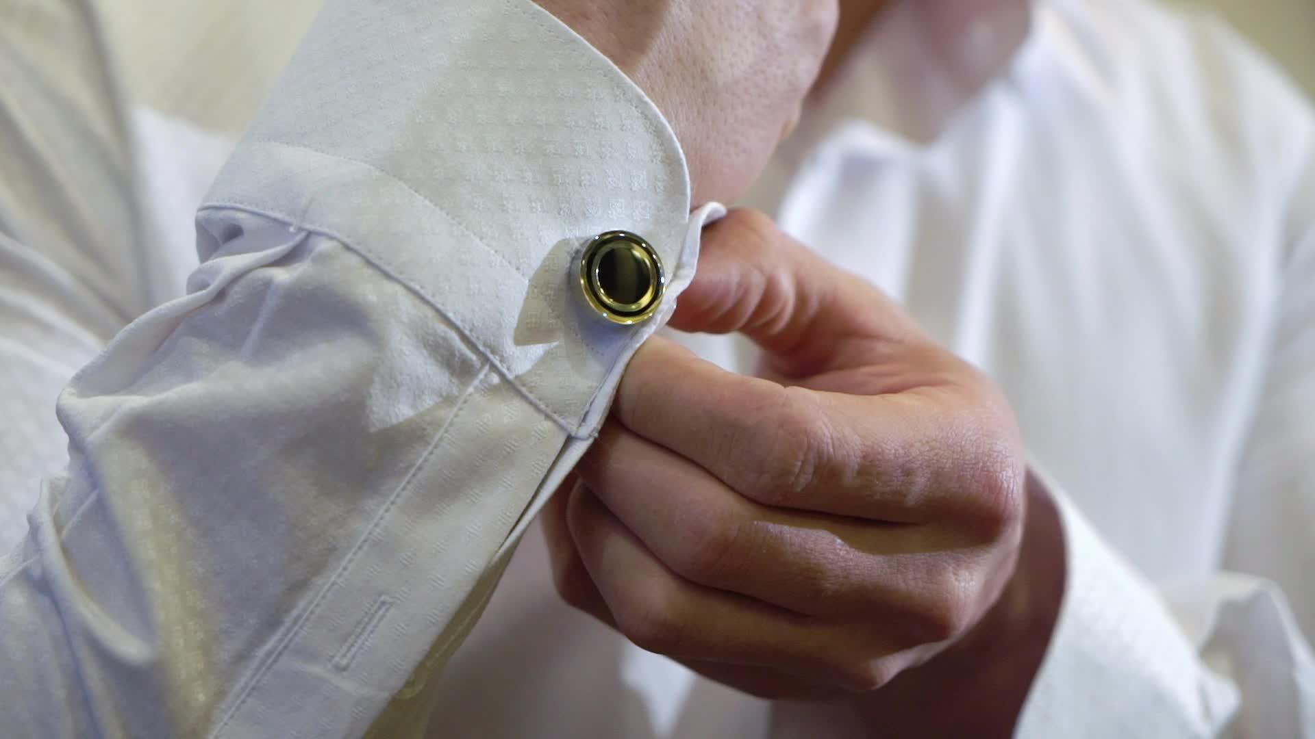 男人戴袖扣系紧白衬衫视频的预览图