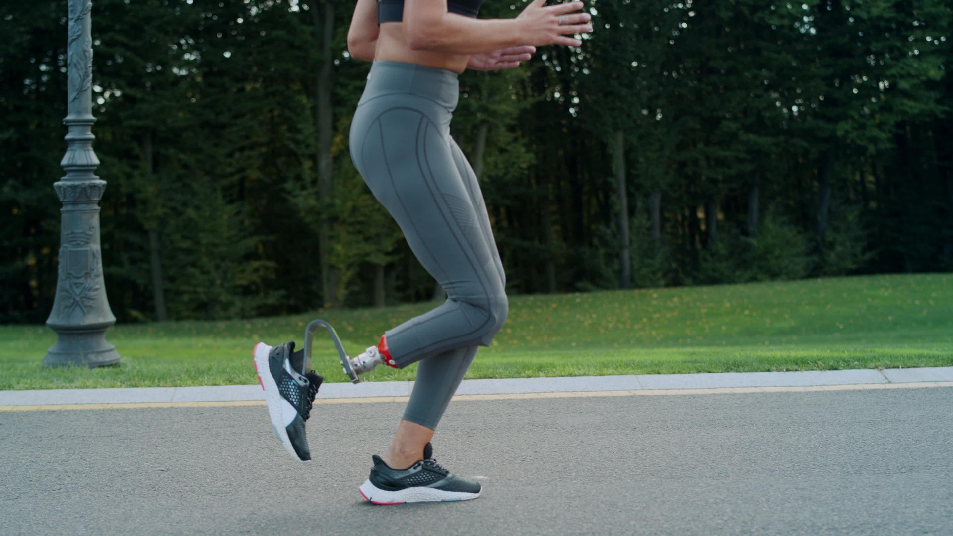 残疾女慢跑运动员在沥青路上跑步视频的预览图