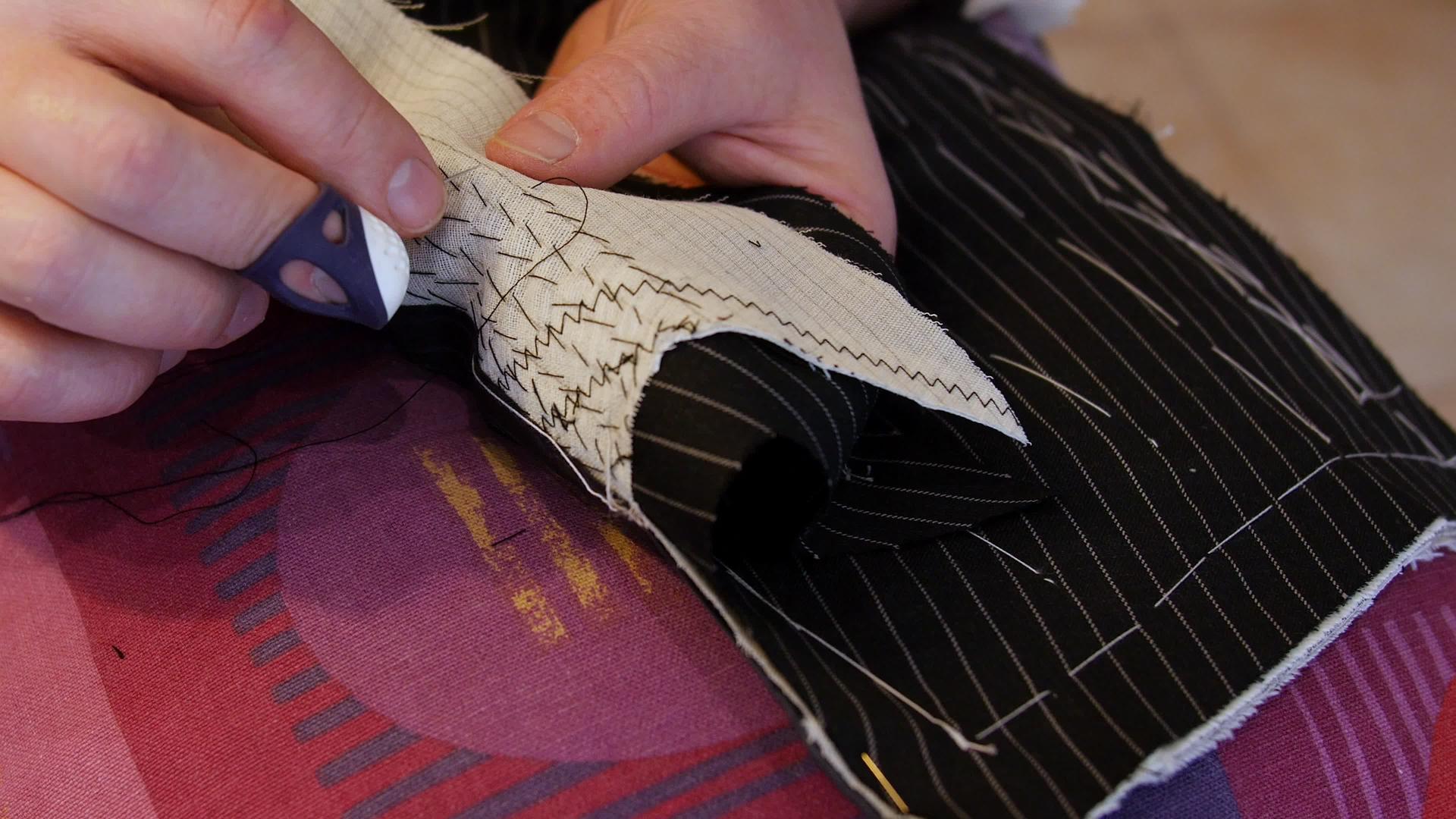 帅气的裁缝女裁缝手垫缝制西装翻领垫缝线两层或两层以上视频的预览图