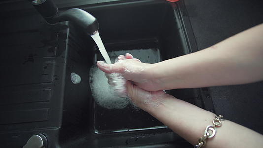 打扫卫生用肥皂洗手年轻女子在浴室的水槽里用肥皂洗手视频的预览图
