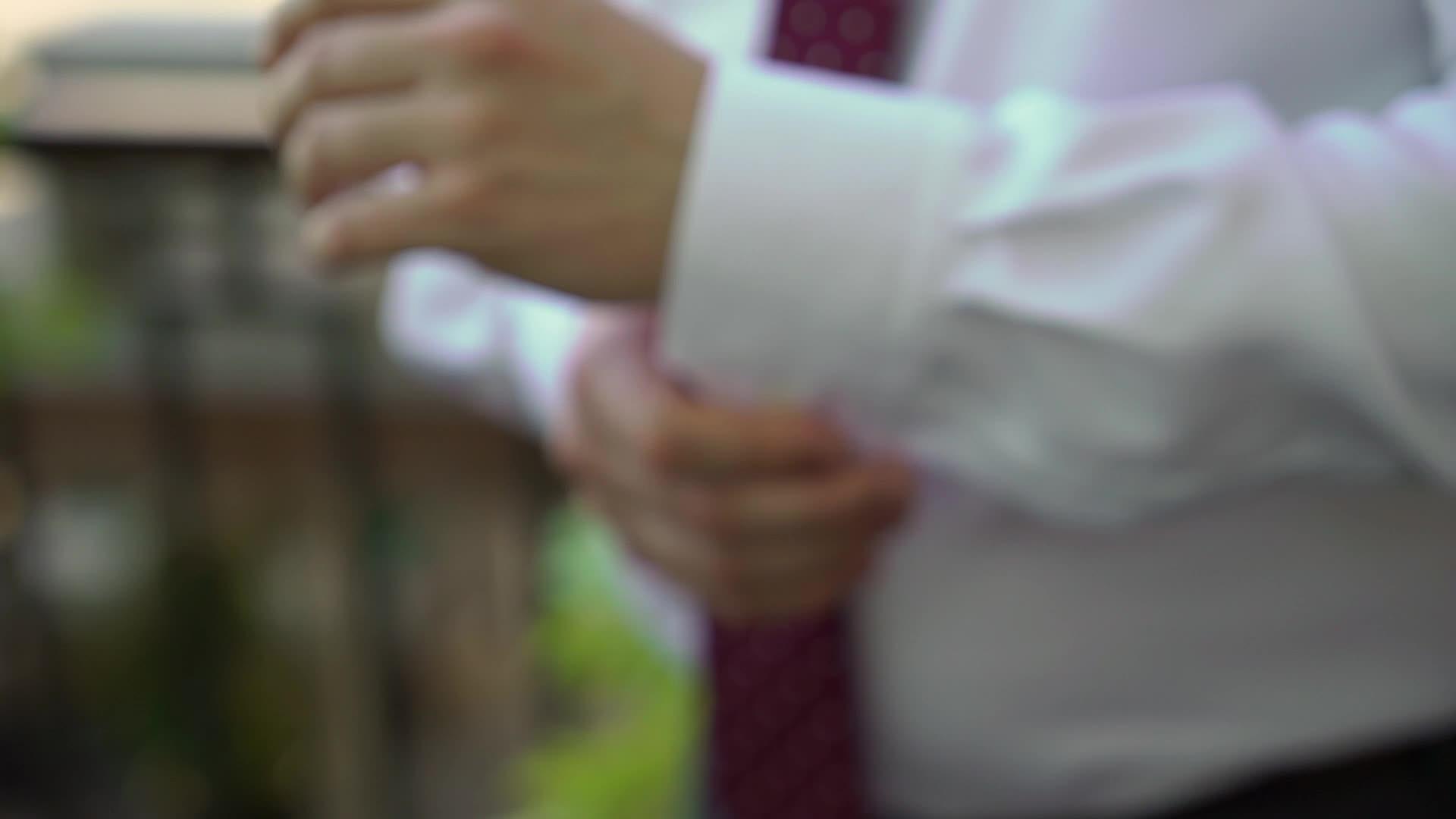 年轻男子戴上袖扣庆祝商业会议或婚礼视频的预览图
