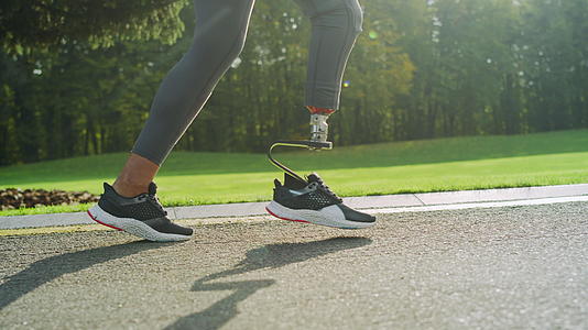 残疾妇女穿着运动鞋在路上开车视频的预览图