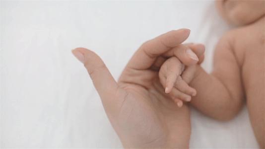 母亲轻轻按摩婴儿的手指视频的预览图