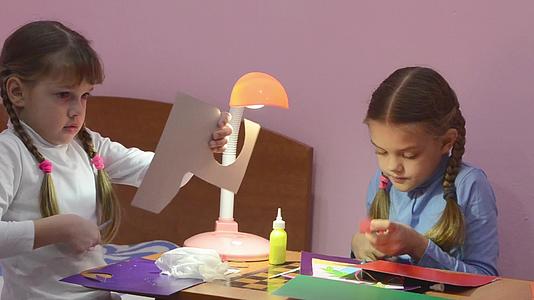 两个孩子用剪刀剪了彩色纸两个孩子做了手工艺品视频的预览图
