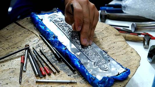 工匠用金属板上的工具雕刻泰国图案视频的预览图