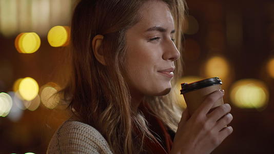 平静的女孩在街上喝咖啡视频的预览图