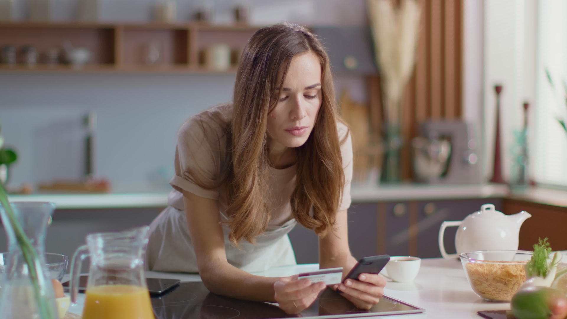 女性在厨房使用智能手机视频的预览图