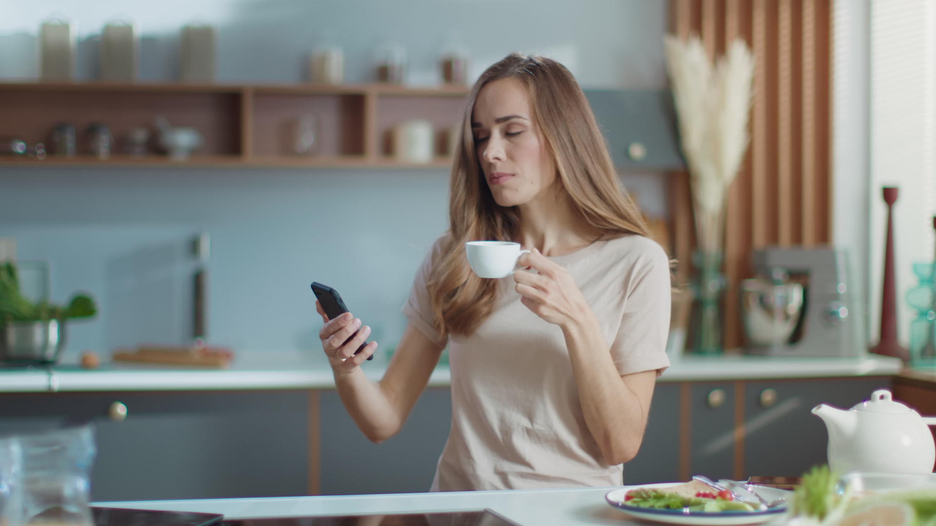女人在厨房的智能手机上自拍视频的预览图
