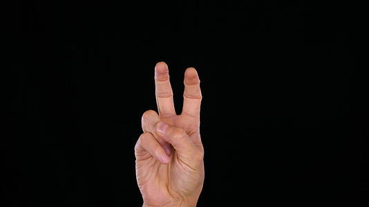 一个男人手里拿着两个手指就像黑色背景上的引号视频的预览图