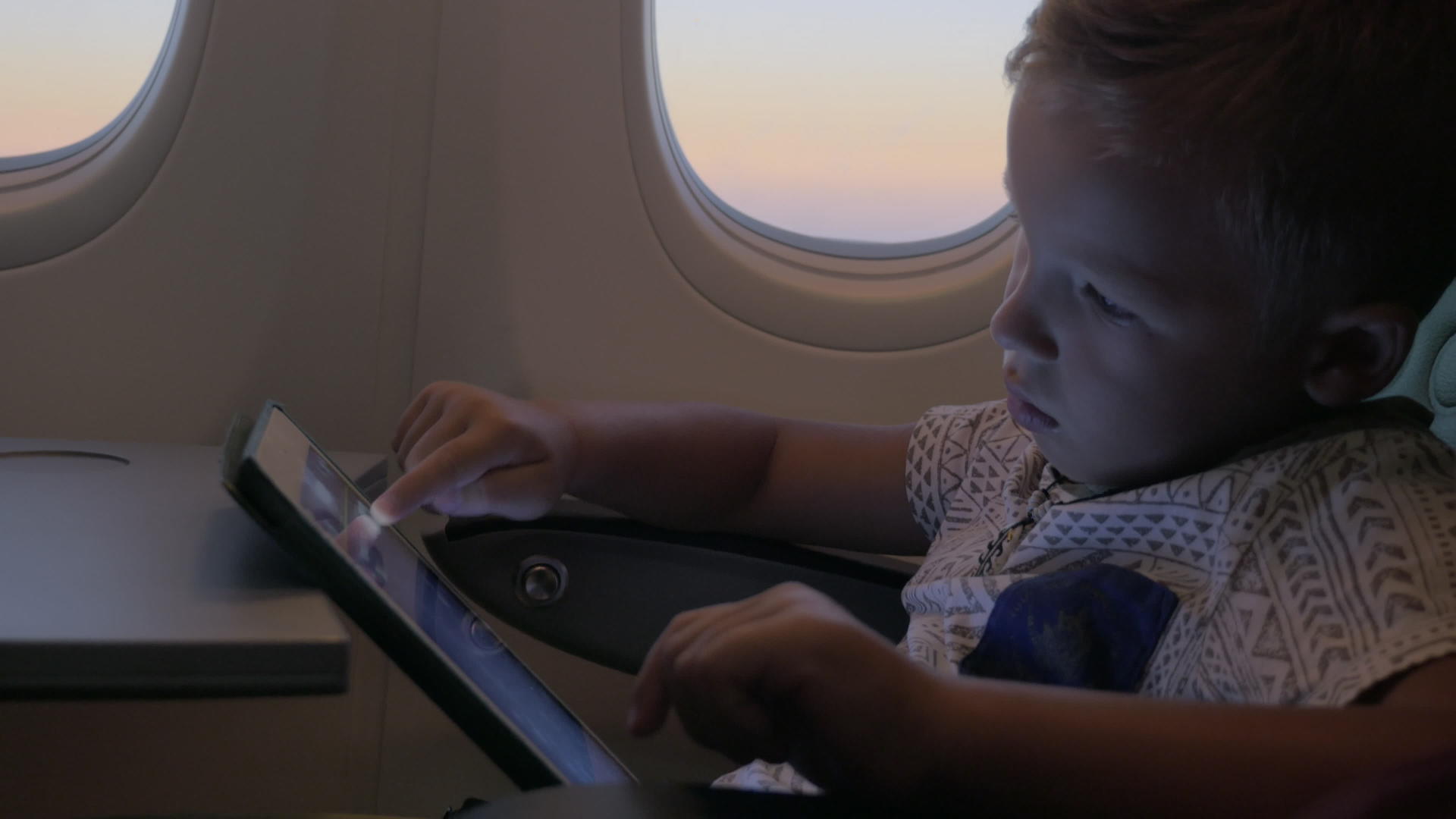 小男孩在飞机上用触摸板在桌子上玩耍视频的预览图