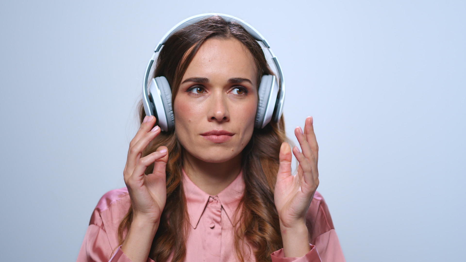 商业女性在工作室用耳机听音乐视频的预览图