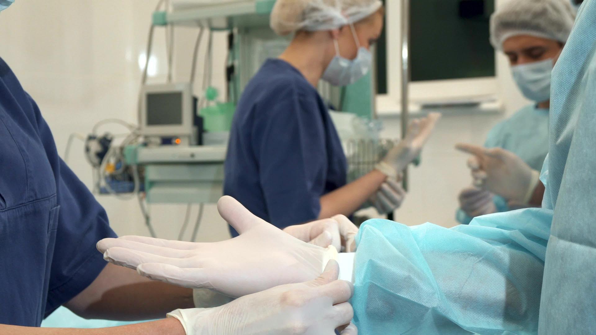 护士在医生的手上戴上手套视频的预览图