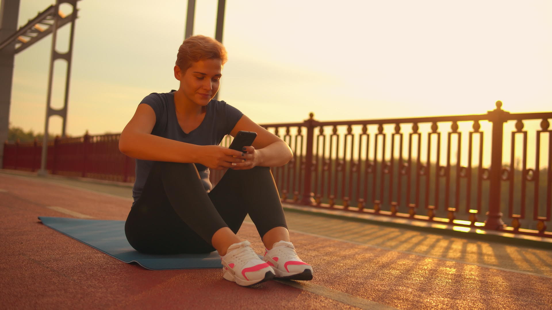 在桥上锻炼后使用手机的女孩视频的预览图