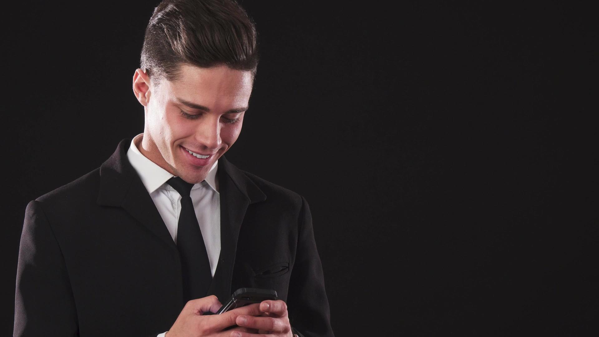 一个微笑的家伙穿着西装在手机里打字视频的预览图