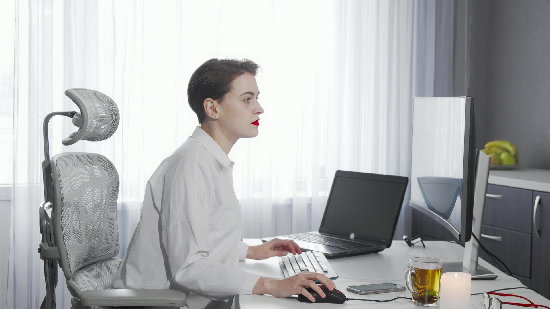 女性自由职业者在计算机工作时使用智能手机视频的预览图