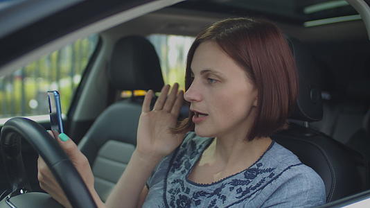 30名女性坐在车里用手机通过视频电话交谈视频的预览图