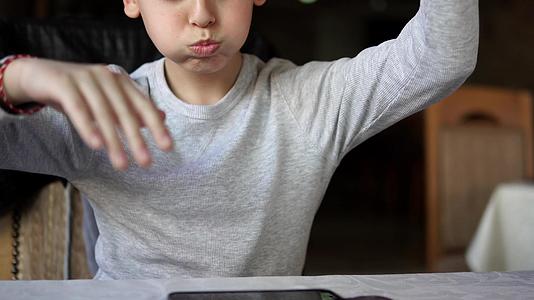 儿童男孩在咖啡馆Dof数字智能手机电脑玩游戏视频的预览图