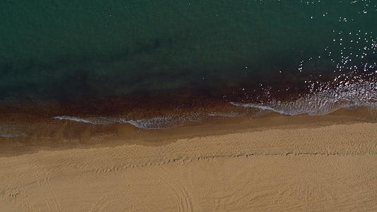 空中的沙滩景观和宁静的蓝色海浪打破了宁静的海滨视频的预览图