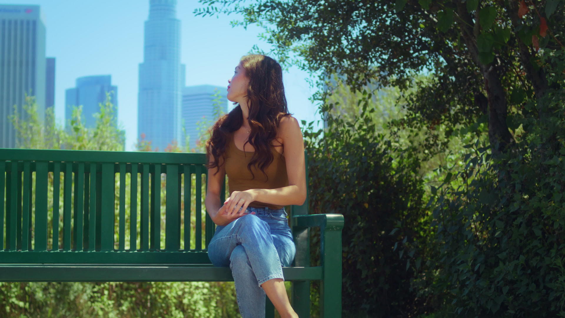 女士坐在长椅上欣赏摩天大楼的风景视频的预览图