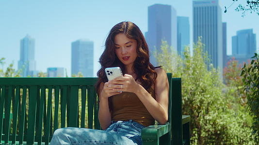 女游客坐在长凳上拨打电话号码视频的预览图