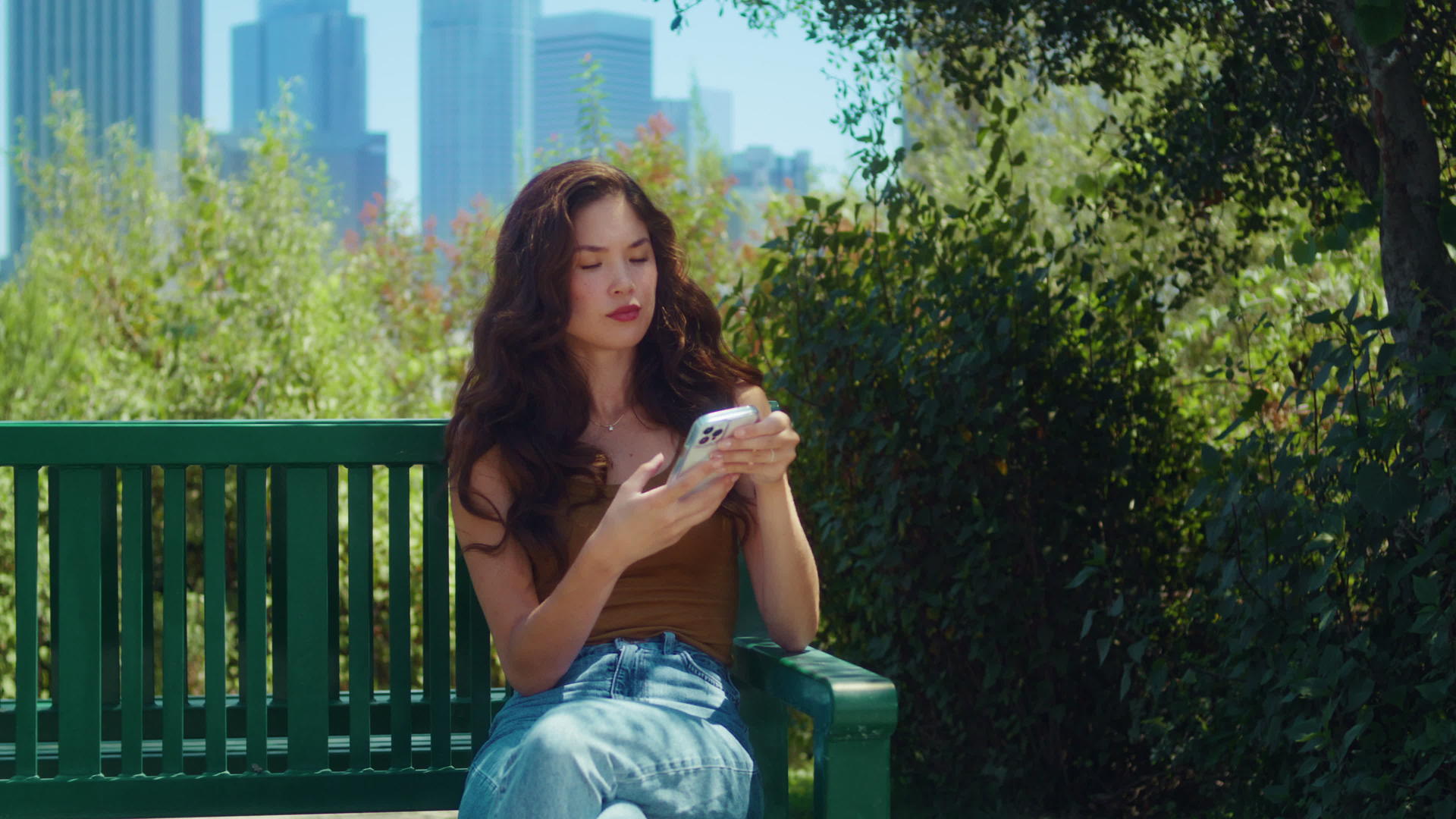 坐在公园长椅上的亚洲女孩拿着电话视频的预览图