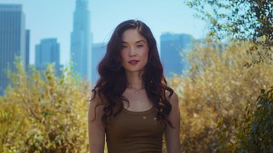 亚洲年轻女子站在公园特写镜头里视频的预览图