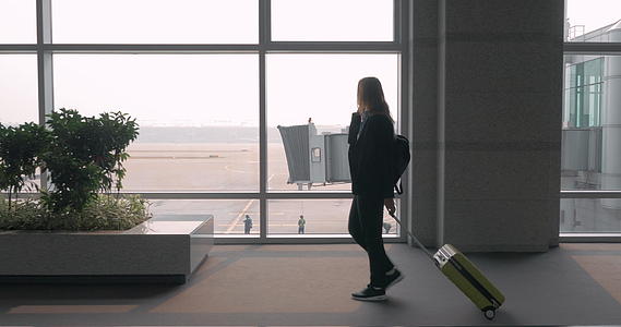 女人在机场候机楼的电话里聊天视频的预览图
