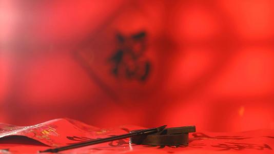 新春福字红色背景前笔墨砚台静物实拍视频的预览图