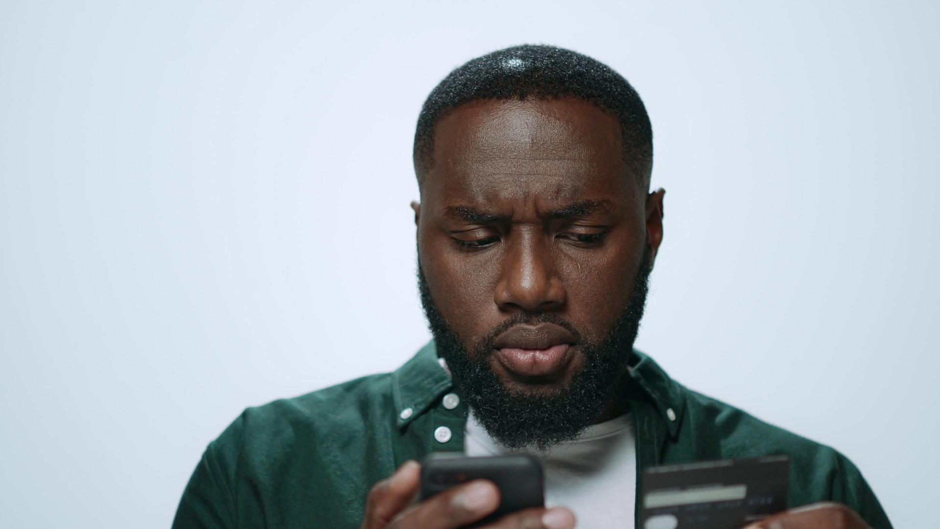 专注的非洲男子在工作室智能手机网上购物成功视频的预览图