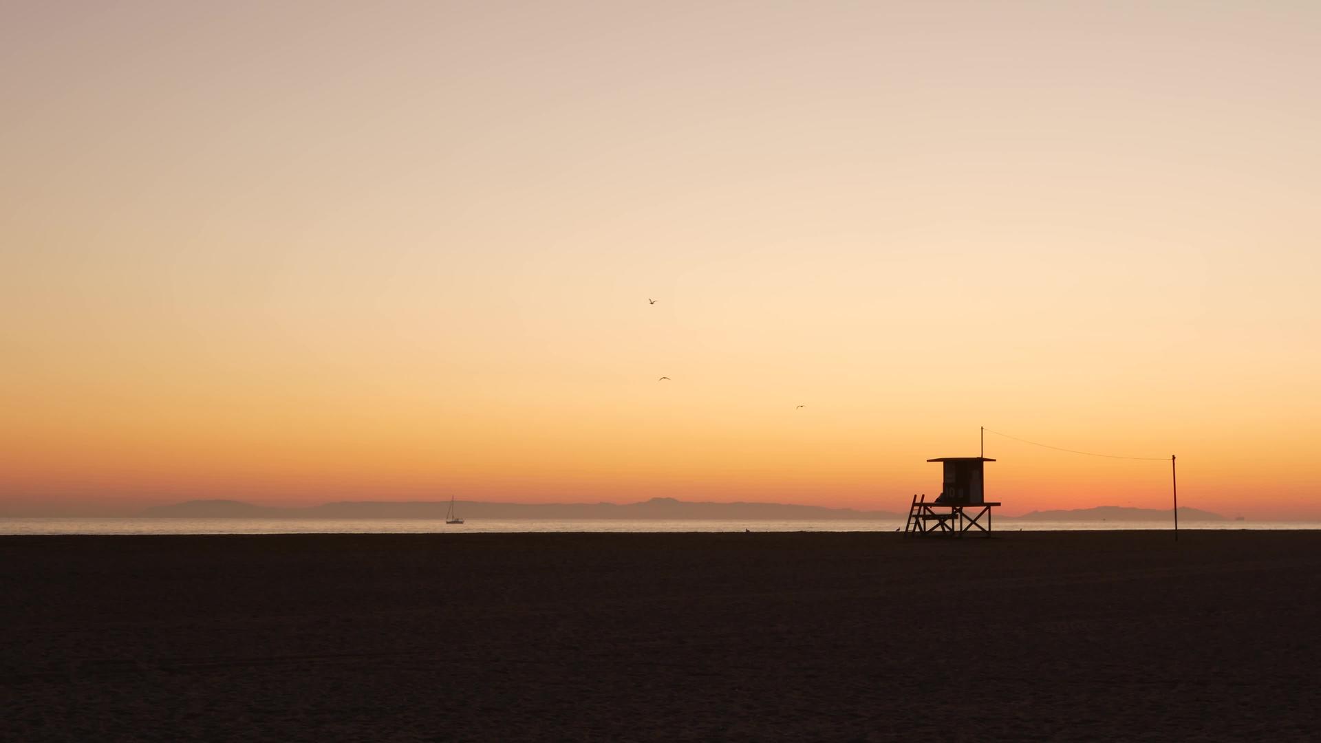 古老的木制救生员望塔与日落的橙色天空相对视频的预览图