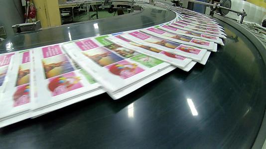 印刷厂工厂杂志在印刷机和文件夹后的传送带线路上运输视频的预览图