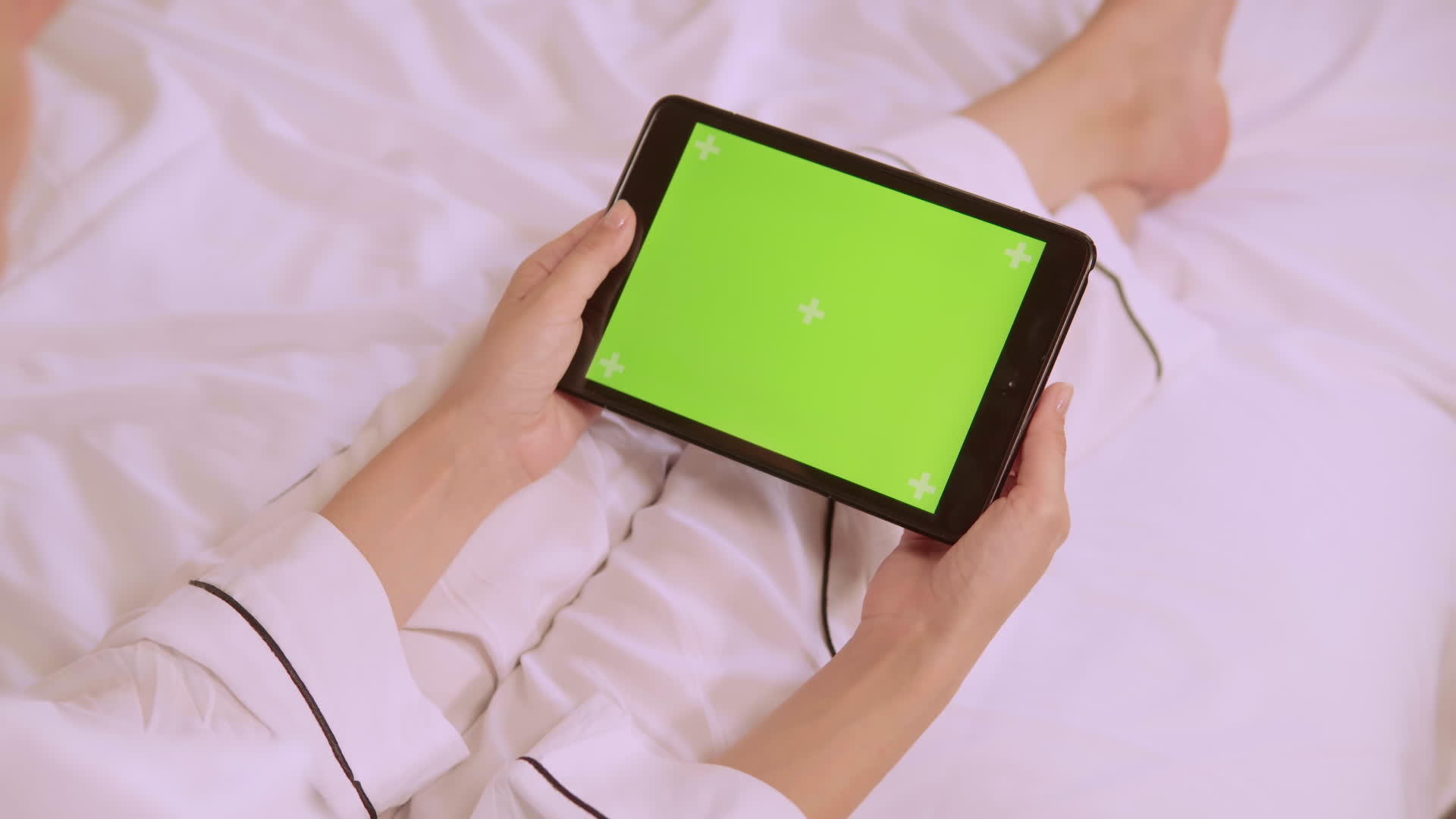 一名穿着白色丝绸睡衣的近身女子坐在床上手里拿着智能便士视频的预览图