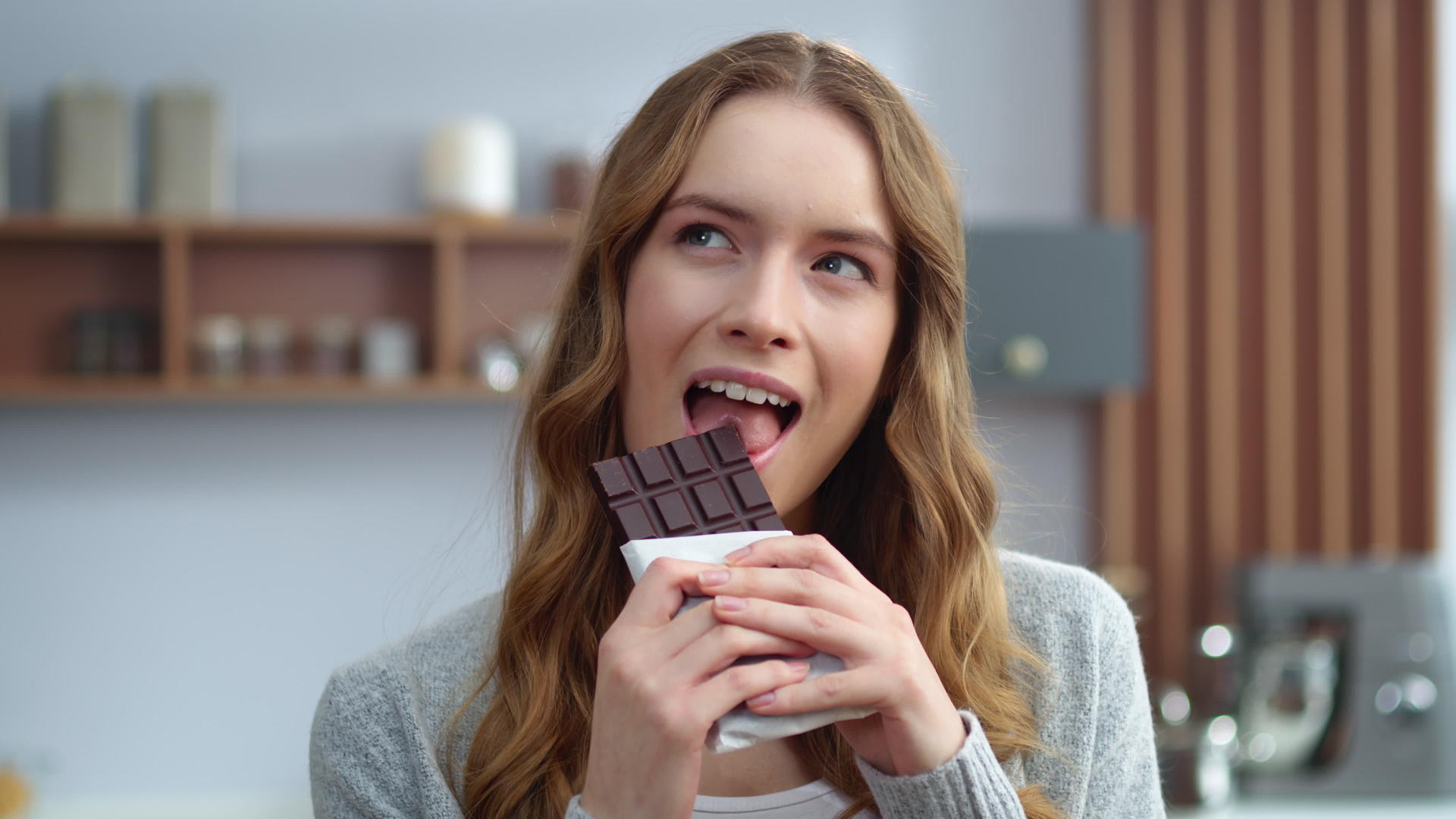 美丽的女孩在室内品尝巧克力的味道视频的预览图