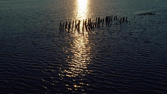 夏日傍晚海景平静海面反射明亮的金色日落视频的预览图