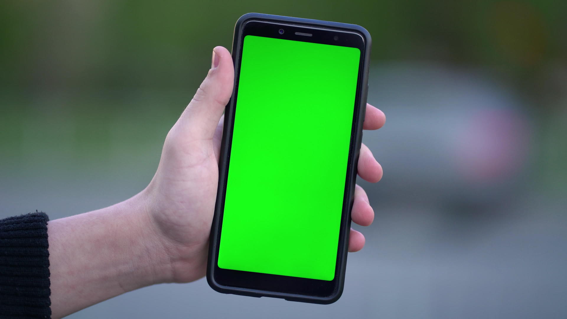 男子在街上拿着假智能手机和绿色屏幕视频的预览图