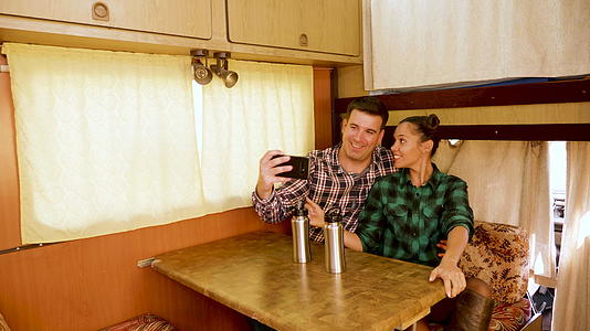 美丽的年轻夫妇在他们的旧露营车里自拍视频的预览图