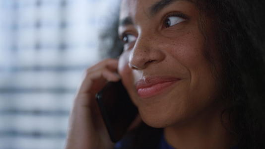 微笑的女商务人士CEO总裁在窗口办公室打电话给手机谈生意视频的预览图