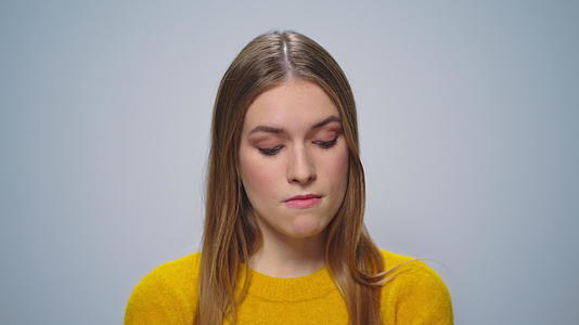 不满意的女模特在演播室思考灰色背景视频的预览图