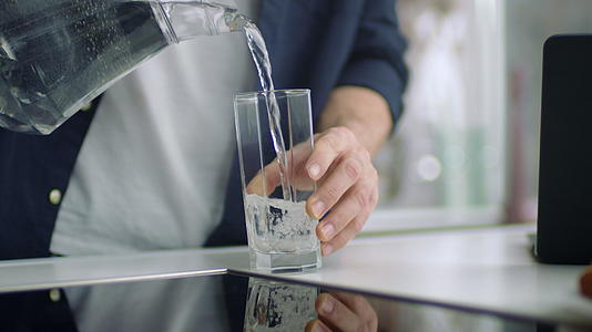 男子把水倒进玻璃杯里视频的预览图