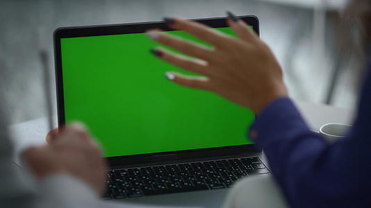 多种族同事团队在办公桌前使用笔记本电脑绿屏进行视频聊天视频的预览图