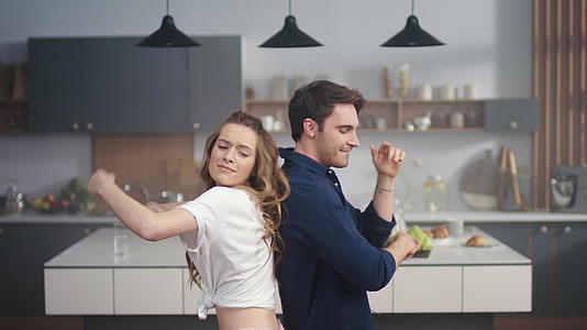 快乐的男人和女人在家里的厨房里视频的预览图